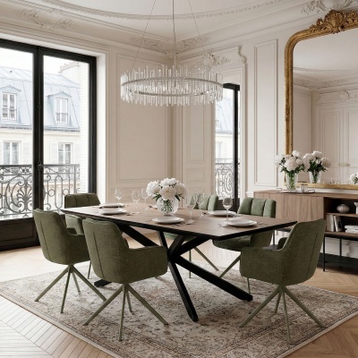 Conjunto de cadeiras verdes estofadas e mesa de madeira numa sala elegante com espelho grande e flores.