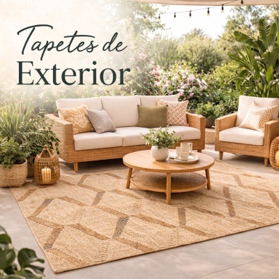 Tapete de exterior com padrão geométrico em ambiente com sofá e cadeira de vime, mesa de madeira e plantas