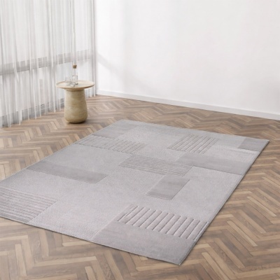 Tapete cinza claro com padrões geométricos texturizados em chão de madeira
