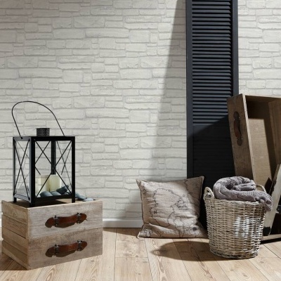 Decoração com caixa de madeira, cesto de vime, almofada, candeeiro e objetos decorativos junto a parede tijoleira branca