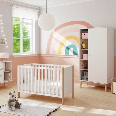 Quarto infantil com móveis brancos em madeira clara e parede decorada com arco-íris colorido