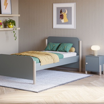 Quarto com cama cinza e mesa de cabeceira com candeeiro branco
