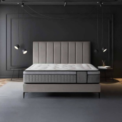 Cama moderna cinza com colchão em quarto de parede cinza escuro e iluminação suspensa