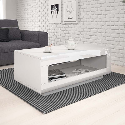 Mesa de centro branca com prateleira aberta em sala moderna com sofá cinza e parede de tijolos brancos.