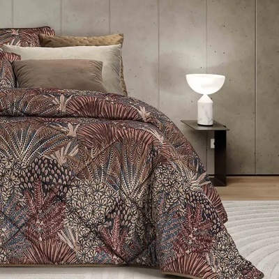 Cama com edredão estampado botânico e almofadas castanhas numa decoração moderna