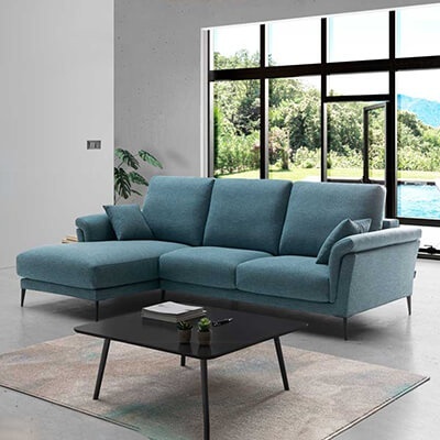 sofá de canto azul em sala moderna com mesa de centro preta e grande janela