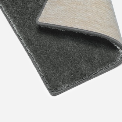 Tapete cinzento escuro e bege dobrado sobre fundo branco