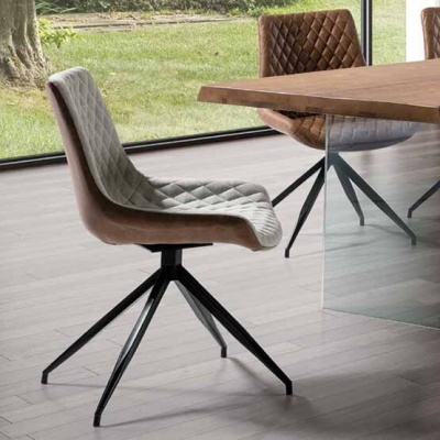 Cadeiras estofadas cinzento claro e pele castanha com padrão losango junto a mesa de madeira e vidro