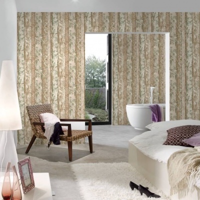 Quarto com cadeira de vime, candeeiro, cama e cortinas florais, vista de casa de banho com banheira