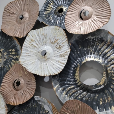 Discos decorativos metálicos de parede com texturas e tons dourados, pretos, brancos e castanho