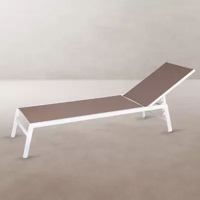 Espreguiçadeira branca com superfície castanha numa sala com chão cinzento