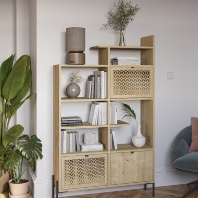 Estante de madeira clara com portas em rattan e decoração minimalista numa sala com chão em espinha.