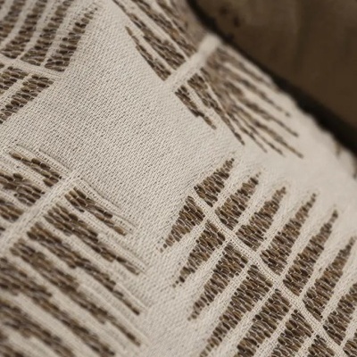 Tecido bege com padrão geométrico castanho em textura detalhada.