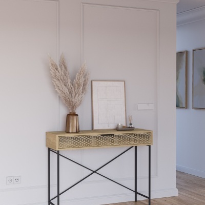 Consola de madeira clara com pernas pretas contra parede branca com decoração em vaso e moldura