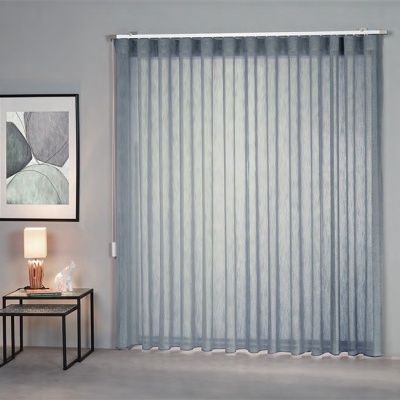 Cortina cinzenta pregueada num ambiente moderno com mesa lateral, lâmpada e quadro decorativo