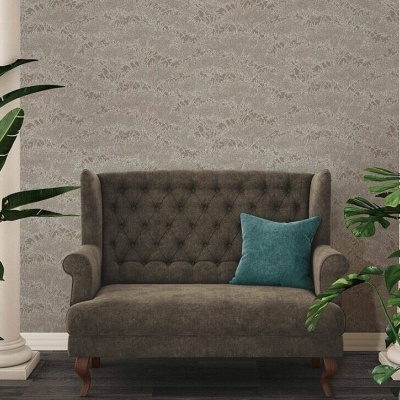 Sofá castanho de dois lugares com almofada azul em sala com piso de madeira, paredes cinza texturas, colunas brancas e plantas verdes.