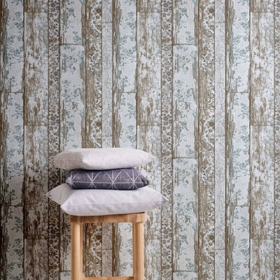 Três almofadas cinza e branca sobre banco de madeira diante de papel de parede texturizado