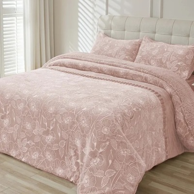 Cobertura de cama rosa claro com padrão floral branco em cama com cabeceira bege
