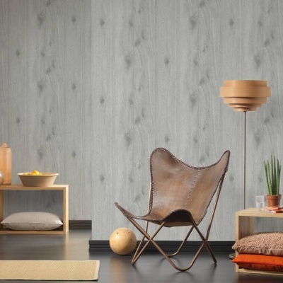 Sala de estar com cadeira de couro castanho, estantes em madeira clara, candeeiro de pé e parede em madeira cinza.