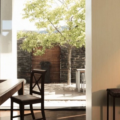 Sala de jantar com mesa, cadeiras, porta para pátio e suporte de parede com colares