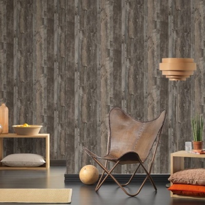 Sala com cadeira de couro marrom e móveis de madeira clara, parede texturizada cinza e castanha