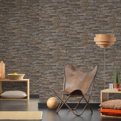 Sala com cadeira de pele castanha, candeeiro de pé madeira, prateleiras e parede de pedra cinzenta