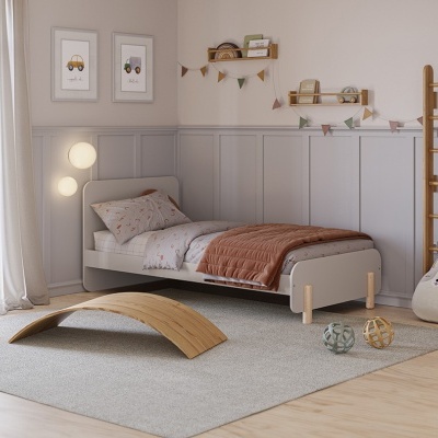 Quarto infantil decorado com cama cinza, têxteis florais, brinquedos de madeira e almofada em forma de animal