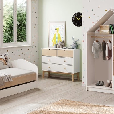 Quarto infantil com mobiliário branco e decoração com bolinhas coloridas na parede