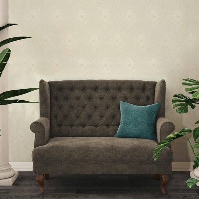 Sofá castanho com almofada azul e plantas em ambiente interior com pilares