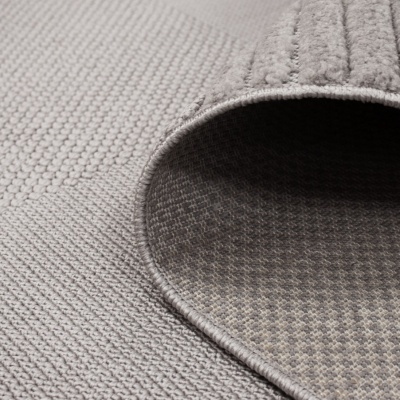 Tapete cinzento claro texturizado parcialmente enrolado