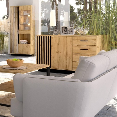 Sala de estar com sofá branco, mesa de café em madeira, aparador e vitrine em madeira clara com detalhes verticais