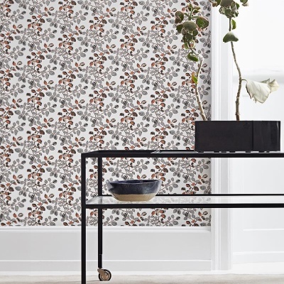 Papel de parede floral em tons castanhos e cinza com mesa de metal preta e vaso de planta