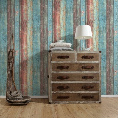 Cómoda rústica em madeira com gavetas, almofadas e lâmpada contra parede colorida