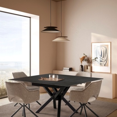 Sala de jantar com mesa preta, cadeiras estofadas bege, luminárias pendentes e decoração na parede.
