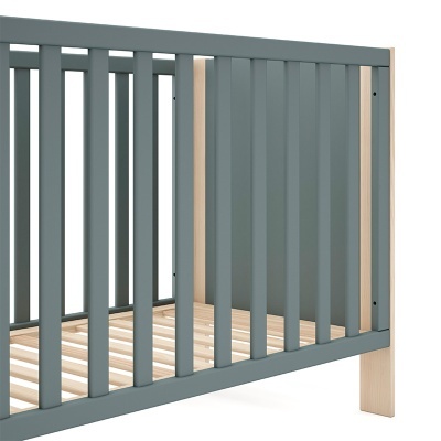 Berço para bebé com laterais cinzentas e estrutura em madeira natural