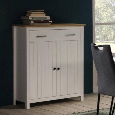 Móvel de arrumação branco com tampo de madeira e puxadores pretos junto a cadeira cinzenta