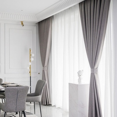 Cortinas cinzentas e brancas numa sala de jantar moderna e luminosa