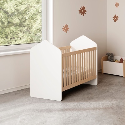 Berço de bebé em madeira clara com laterais brancas e decoração de parede floral