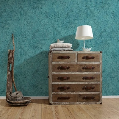 Cómoda de madeira envelhecida com candeeiro e almofadas, parede azul texturizada