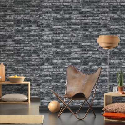 Cadeira em couro castanho com móvel de madeira e candeeiro numa sala com parede de tijolo cinzento