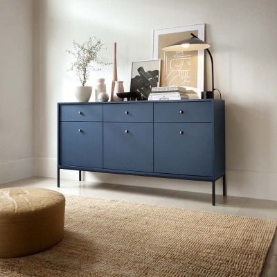 Cómoda azul com decoração em cima e carbete de parede ao fundo