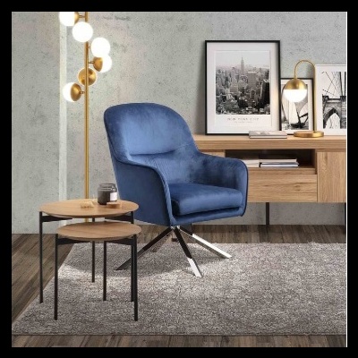 Cadeira azul moderna com mesa de apoio, tapete cinzento, candeeiro dourado e secretária de madeira com quadros em preto e branco