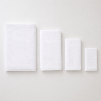 Conjunto de quatro toalhas brancas de diferentes tamanhos dobradas lado a lado.
