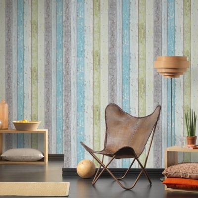 Sala com parede riscada em tons pastel, cadeira de couro castanho e móveis baixos de madeira clara.