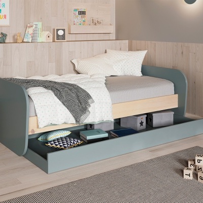 Cama de solteiro cinza-azul com gavetão de arrumação aberto em quarto com decoração minimalista