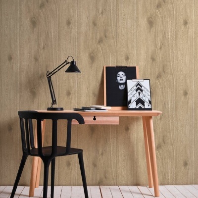 Mesa de escritório em madeira clara com cadeira e candeeiro preto na frente de parede de madeira.