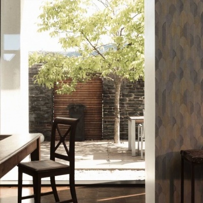 Sala de jantar com mesa e cadeiras de madeira junto a janela aberta para jardim