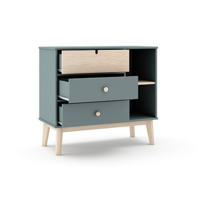 Cômoda azul cobalto com gavetas e prateleira aberta em madeira clara e quatro pés inclinados.