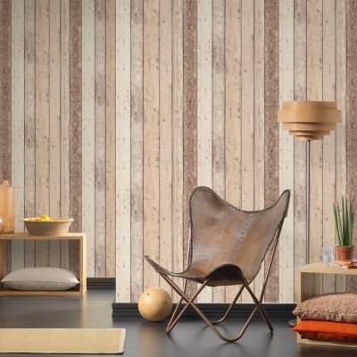 Cadeira de couro castanho e mesa de apoio em madeira clara num ambiente com papel de parede às riscas.