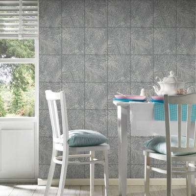 Mesa e cadeiras brancas com almofadas azuis junto a parede de azulejos cinzentos com padrão geométrico